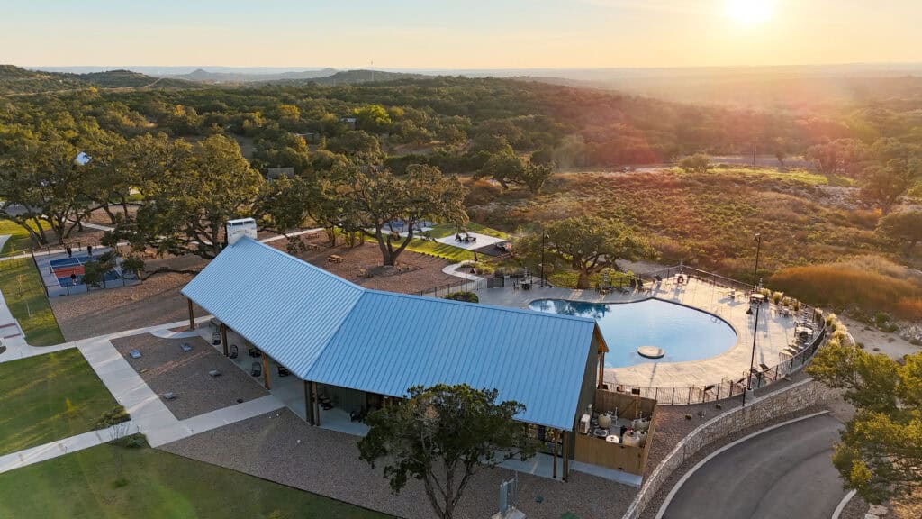 Aerial view of Horseshoe Ridge RV with pool and surrounding nature at sunset.