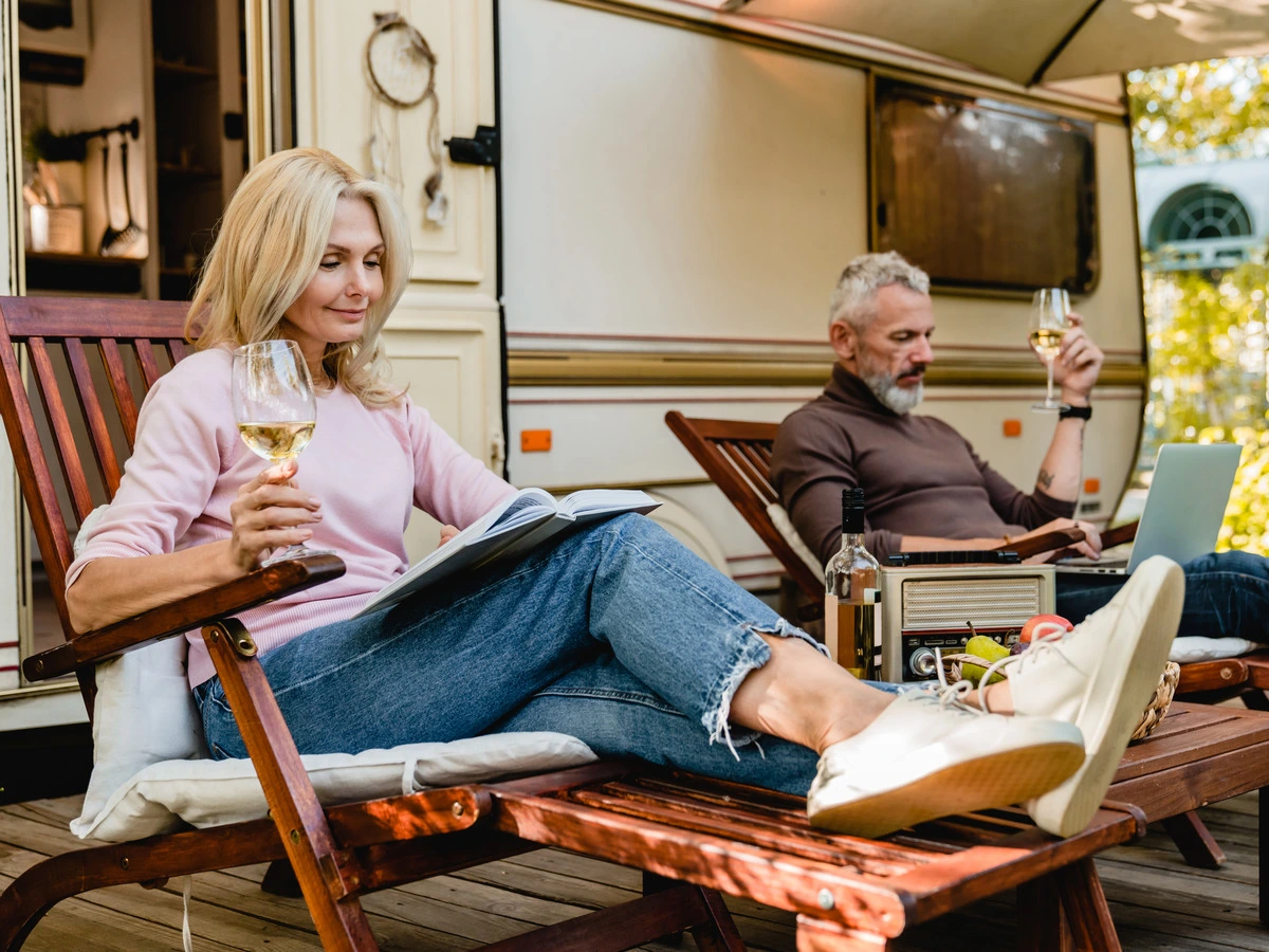 Couple relaxing with a glass of wine beside their RV at Horseshoe Ridge RV Resort, Wimberley TX