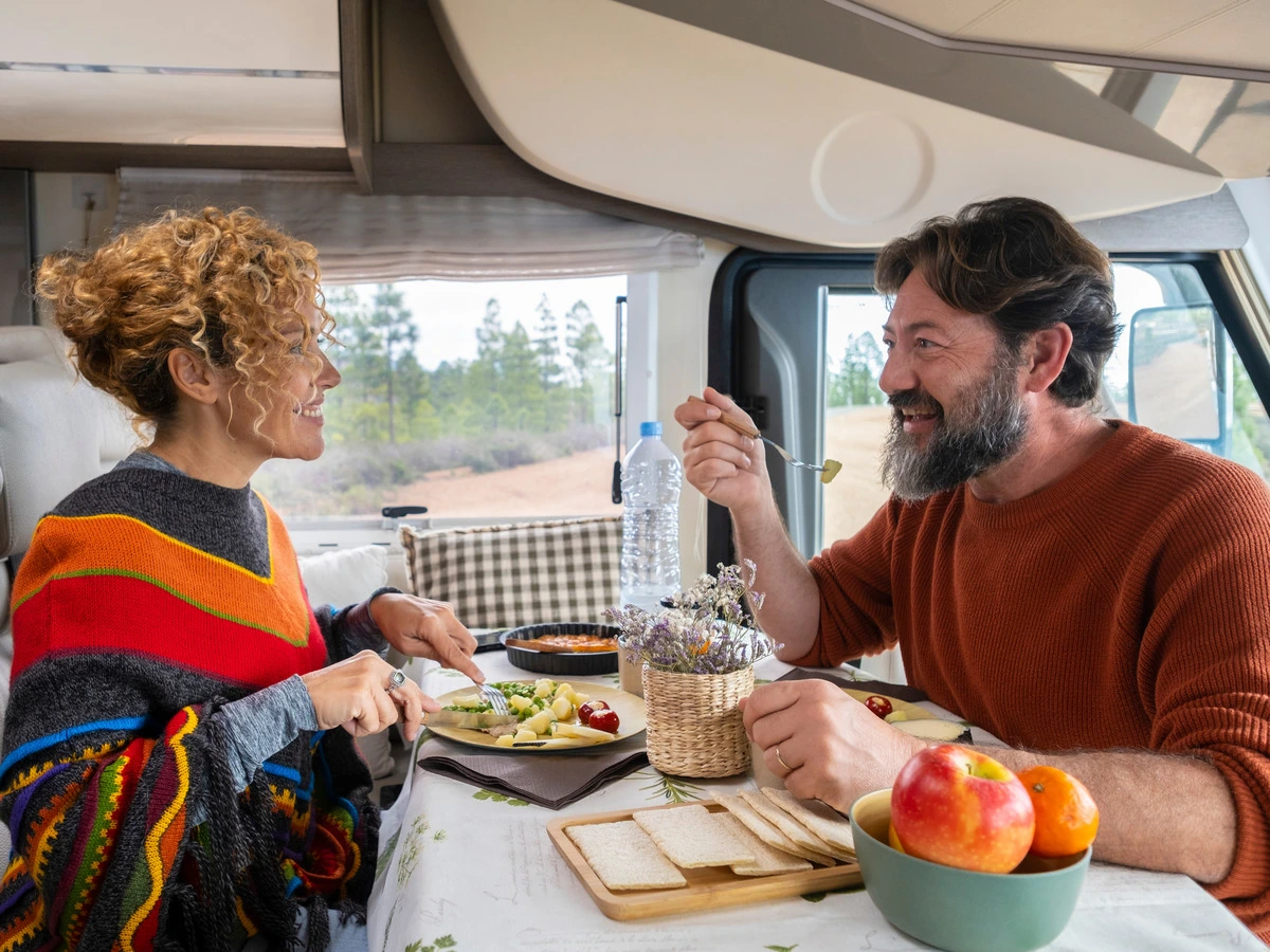 Couple eating inside their RV — ready to hit the road for a Hill Country trip