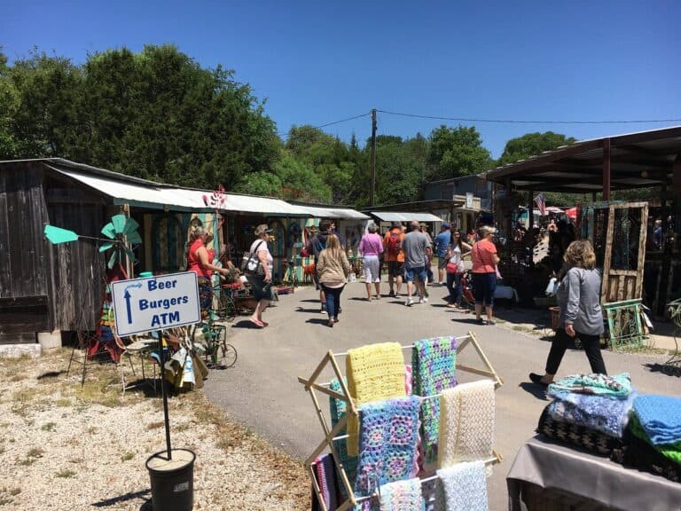 Shoppers browsing outdoor vendor booths in Wimberley, Texas