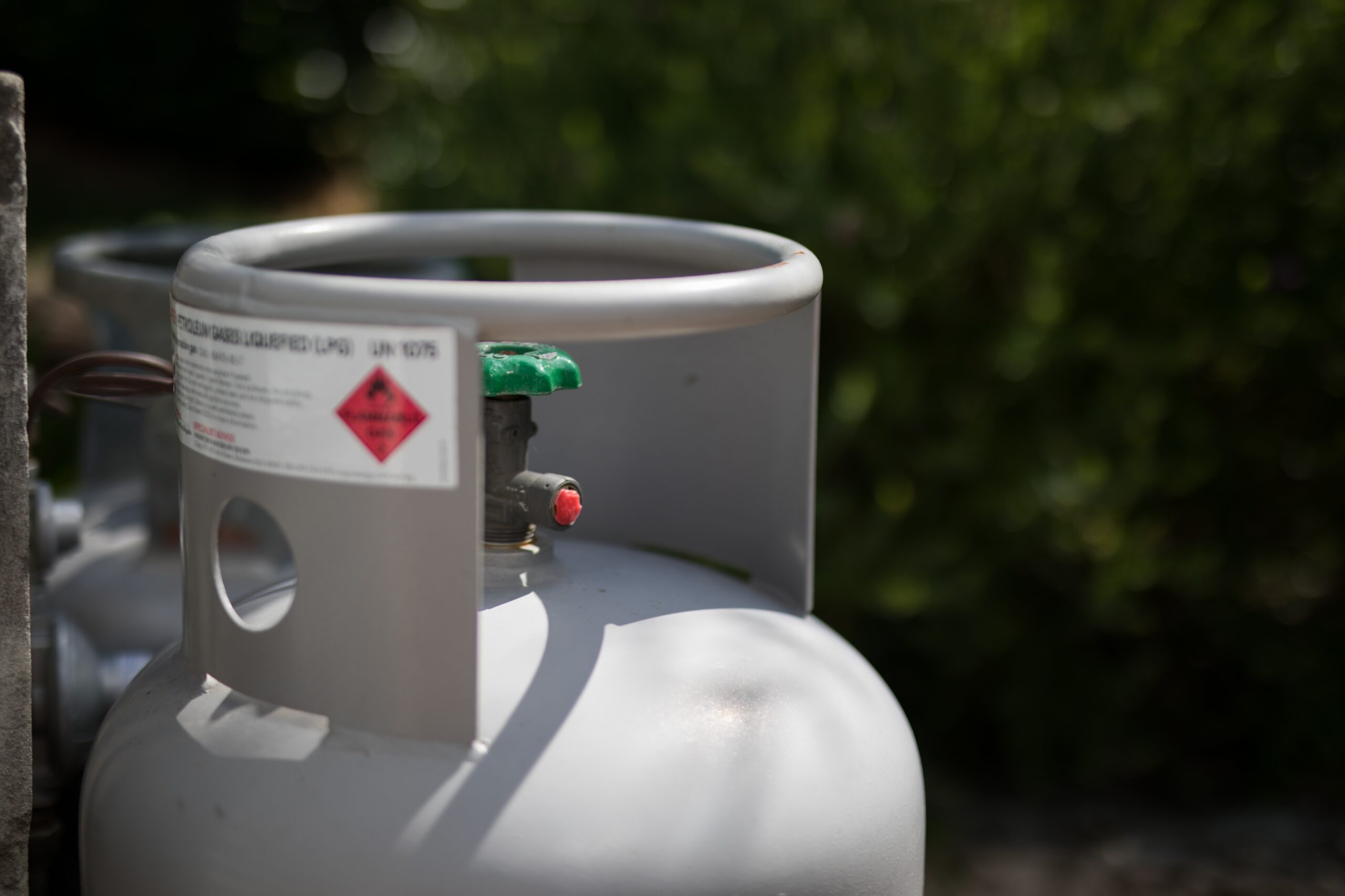 LPG propane cylinder with safety warning label set outdoors before a refill