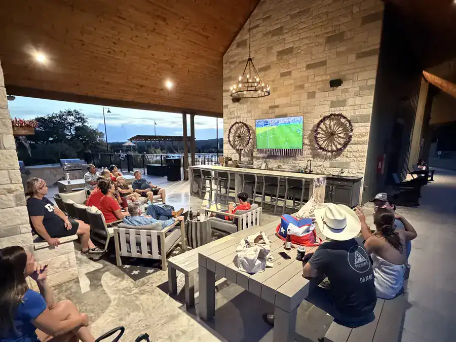 Guests gathered under the pavilion to watch a game on the big screen at dusk