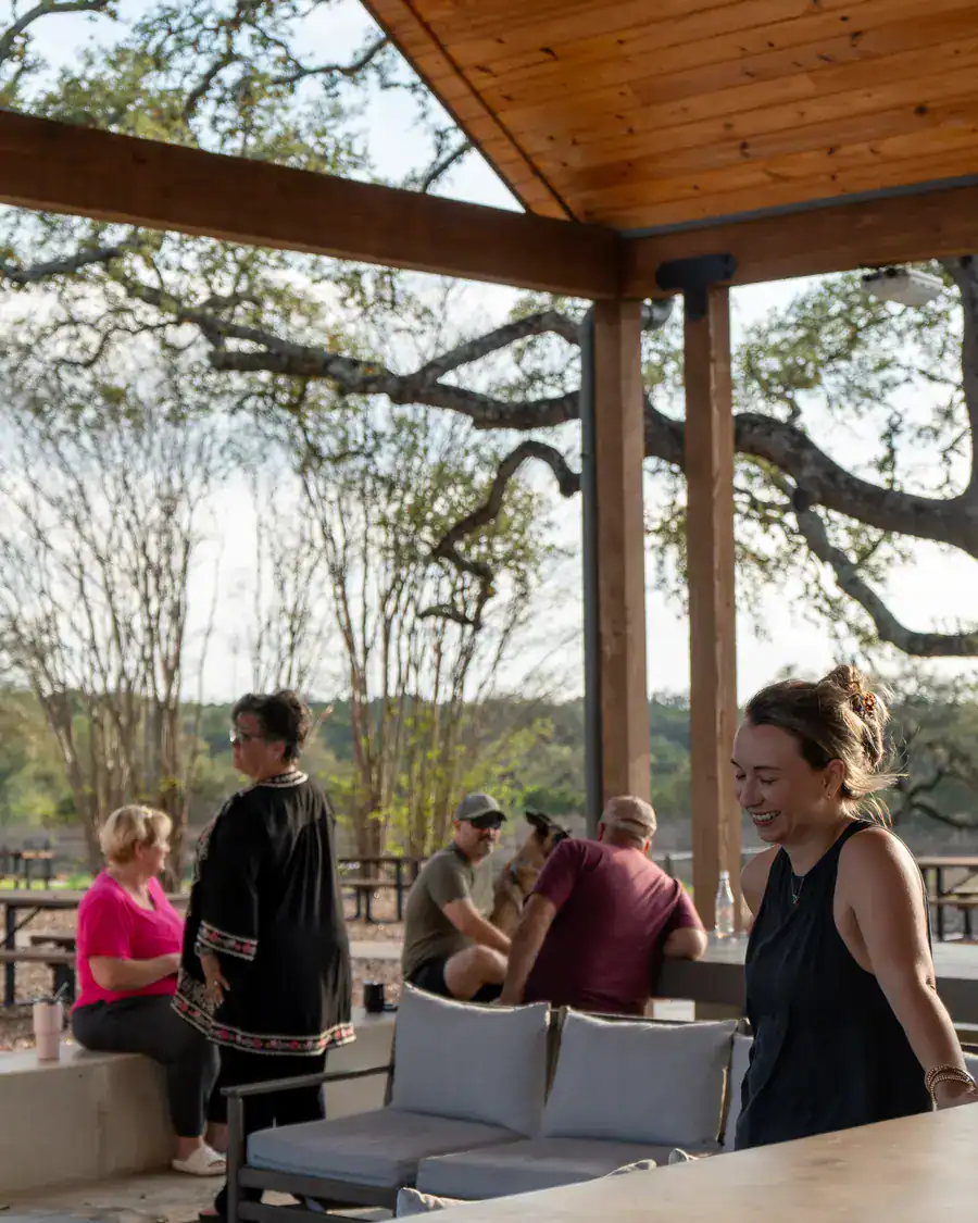 Guests chatting over wine at the covered pavilion in the late afternoon