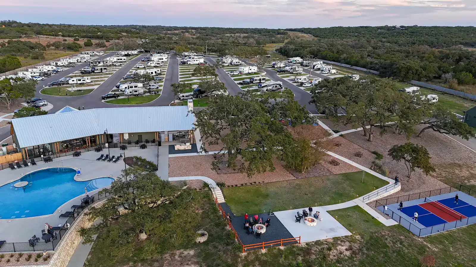 Aerial view of the Horseshoe Ridge clubhouse, pool and community fire pits, with guests around the fire