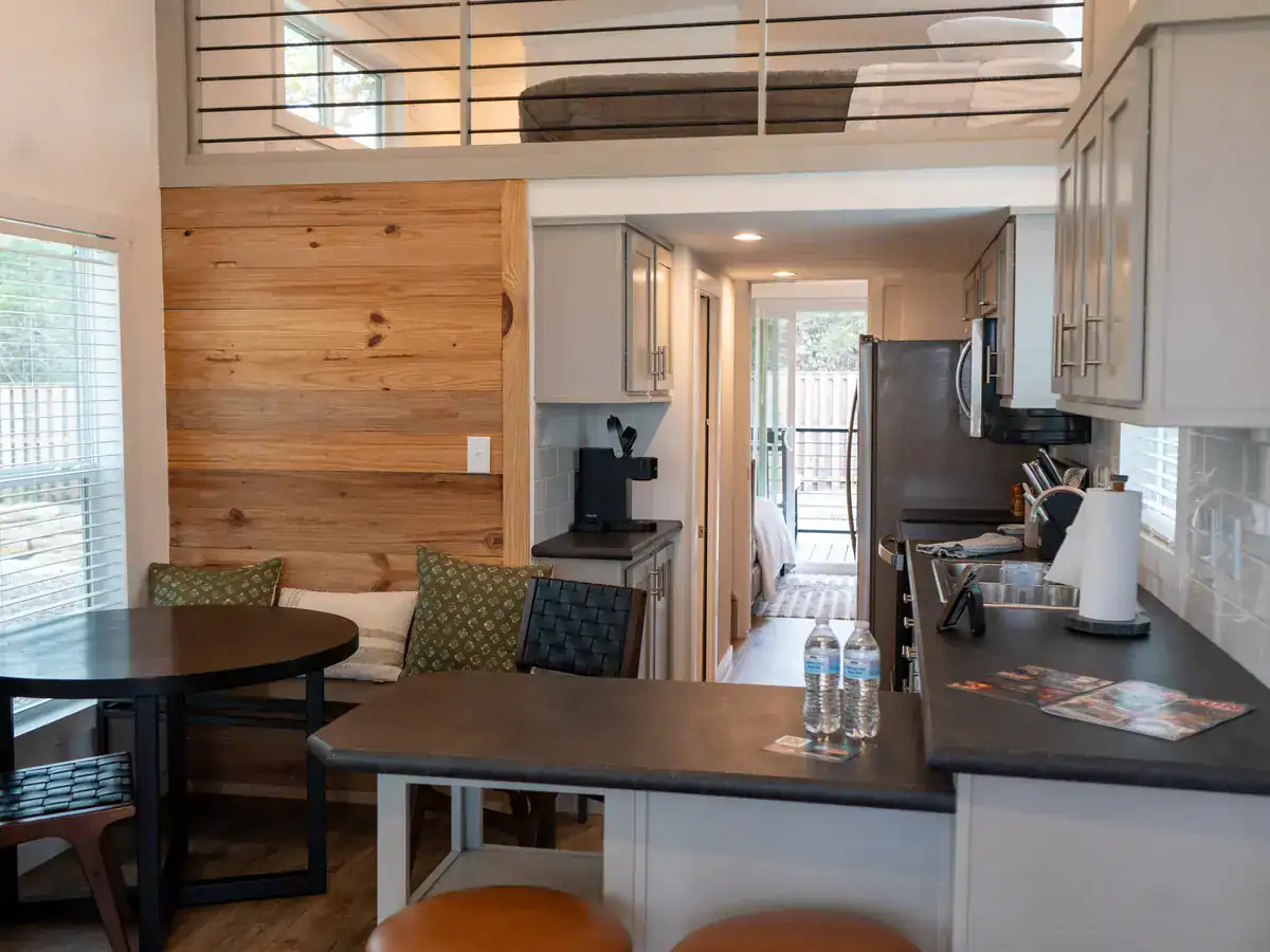 The Mingo cabin interior with a sleeping loft and grey painted kitchen at Horseshoe Ridge
