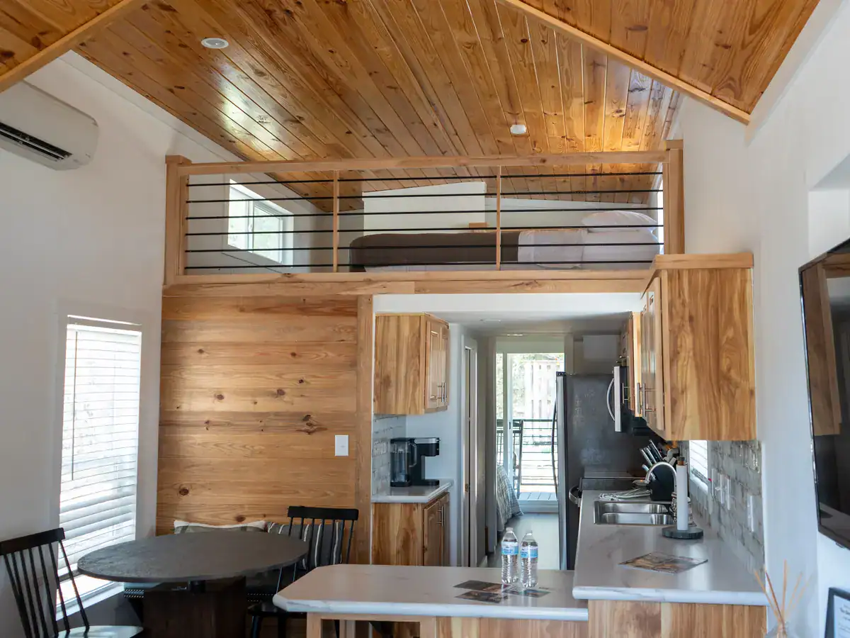 Sea Biscuit cabin interior with a pine ceiling, sleeping loft and open kitchen at Horseshoe Ridge