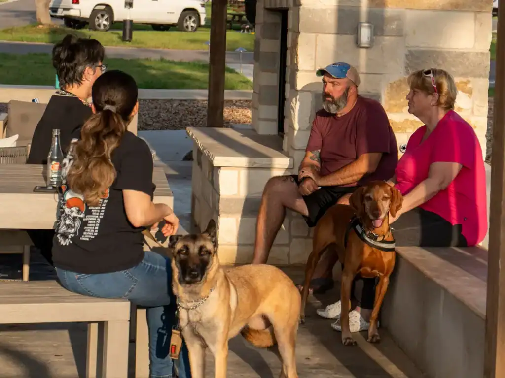 Guests with their two dogs at the pavilion at Horseshoe Ridge RV Resort