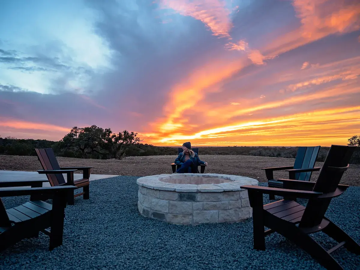 Community fire pit with Adirondack chairs at sunset