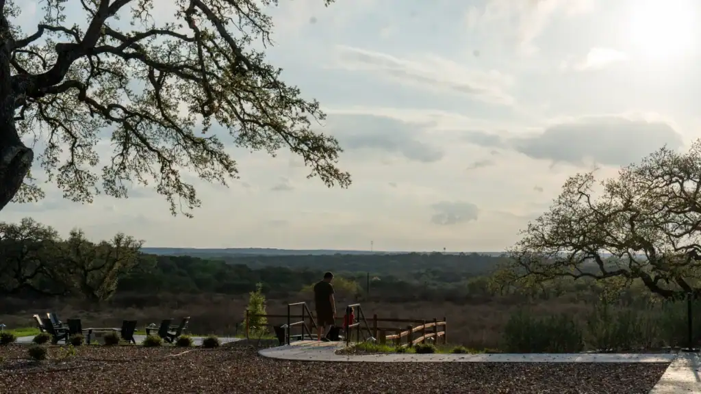 View across the Texas Hill Country from the overlook at Horseshoe Ridge, framed by live oaks