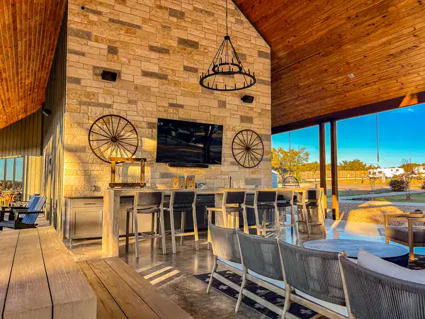 The covered pavilion with its stone fireplace, outdoor kitchen and lounge seating