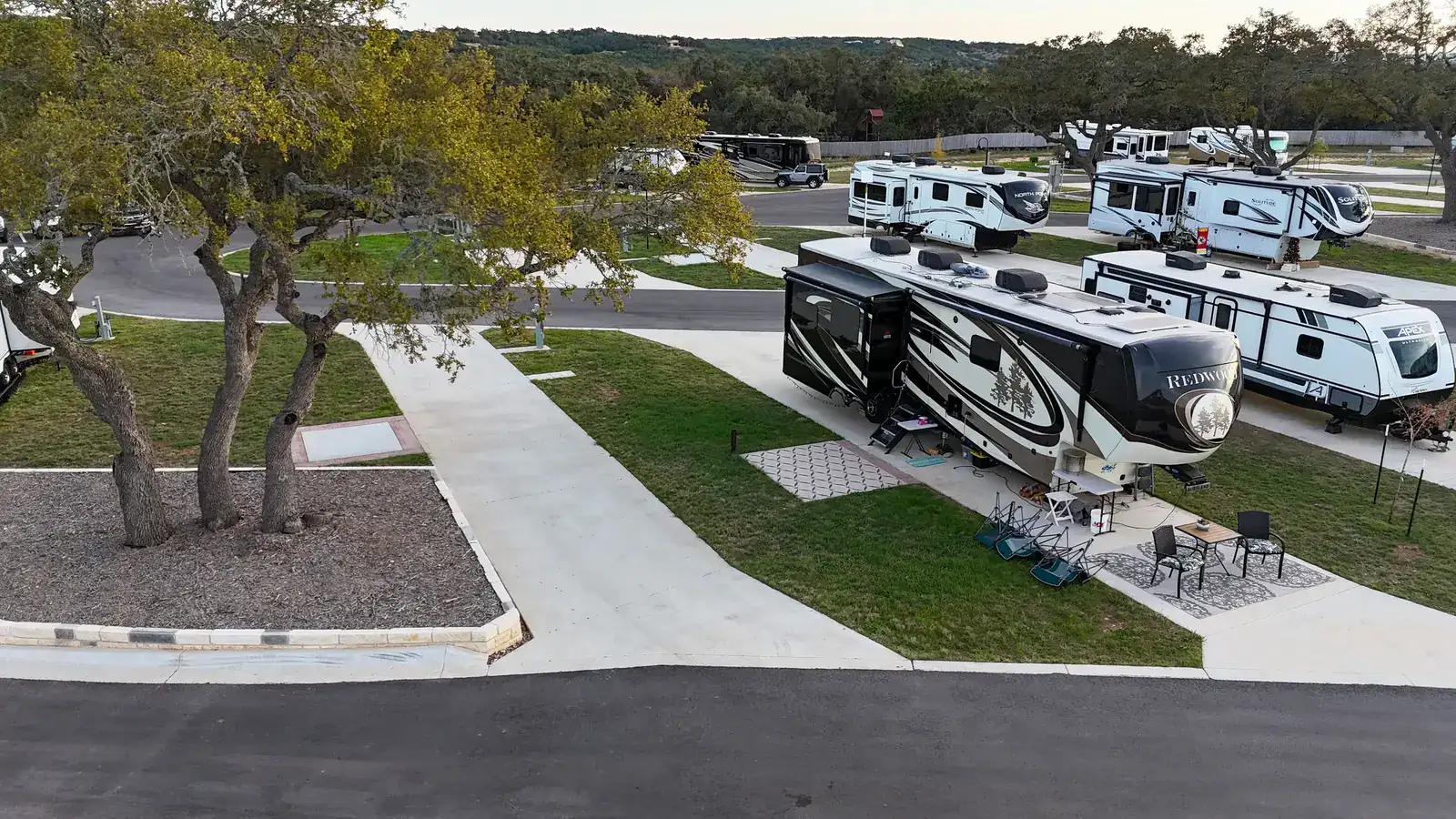 Fifth-wheel RV on a concrete full-hookup site with a patio at Horseshoe Ridge RV Resort in Wimberley, Texas