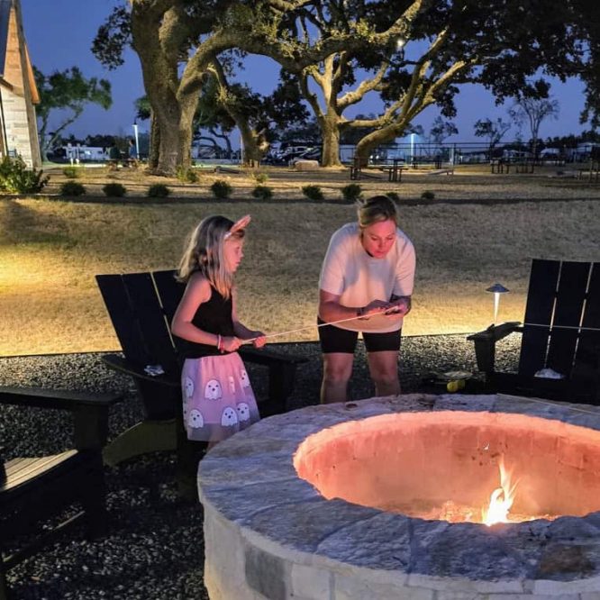 People enjoying a fire pit at Horseshoe Ridge RV amenities at night.