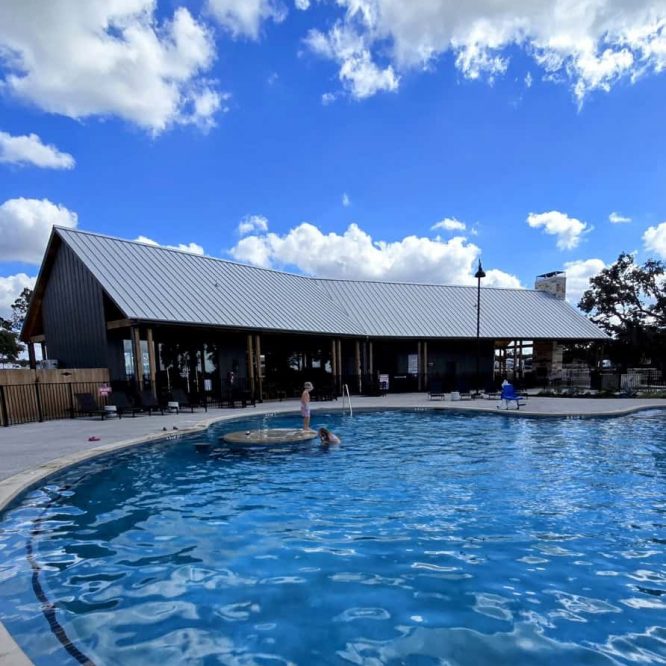 Outdoor swimming pool at Horseshoe Ridge RV with clear blue water and sunny sky.