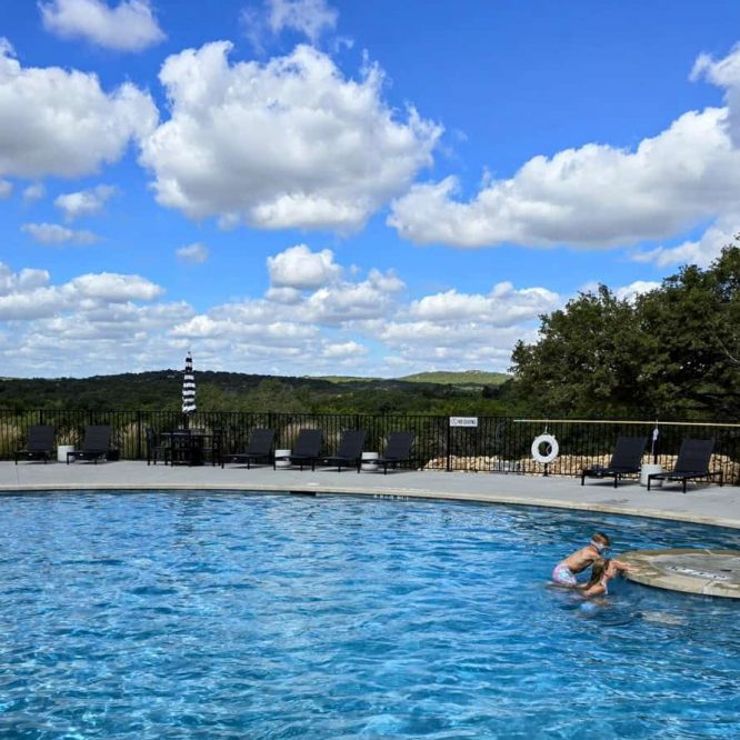 Outdoor swimming pool at Horseshoe Ridge RV with scenic sky and landscape.