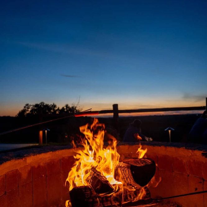 Campfire at Horseshoe Ridge RV during sunset with a clear sky.
