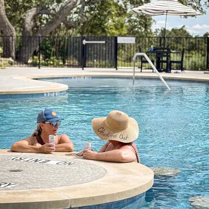 Two women relaxing by the pool at Horseshoe Ridge RV resort.
