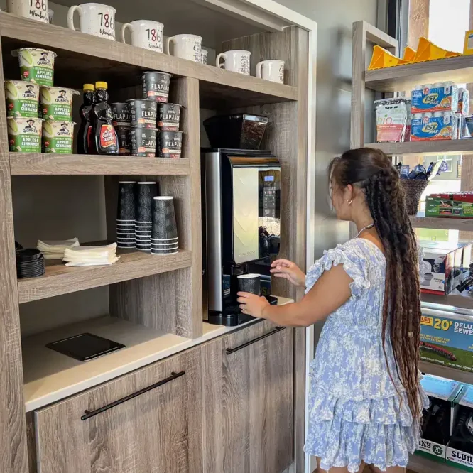 Young girl using a coffee vending machine at Horseshoe Ridge RV.