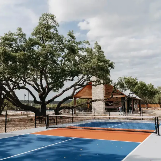 Tennis court at Horseshoe Ridge RV with trees and cloudy sky.