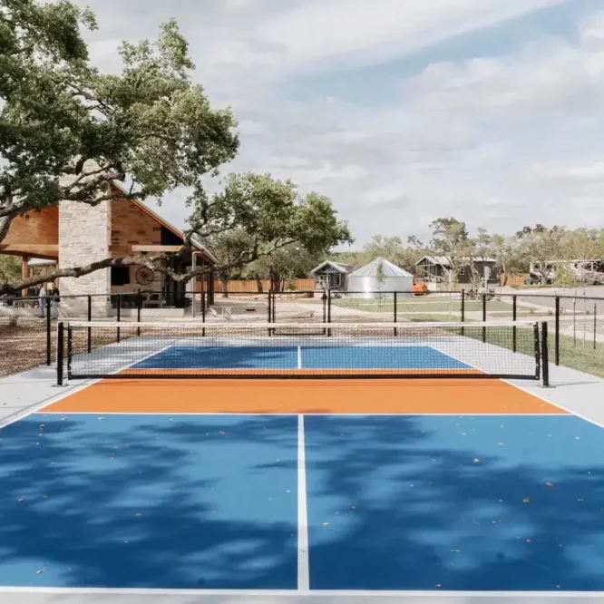 Tennis court at Horseshoe Ridge RV with trees and open sky.