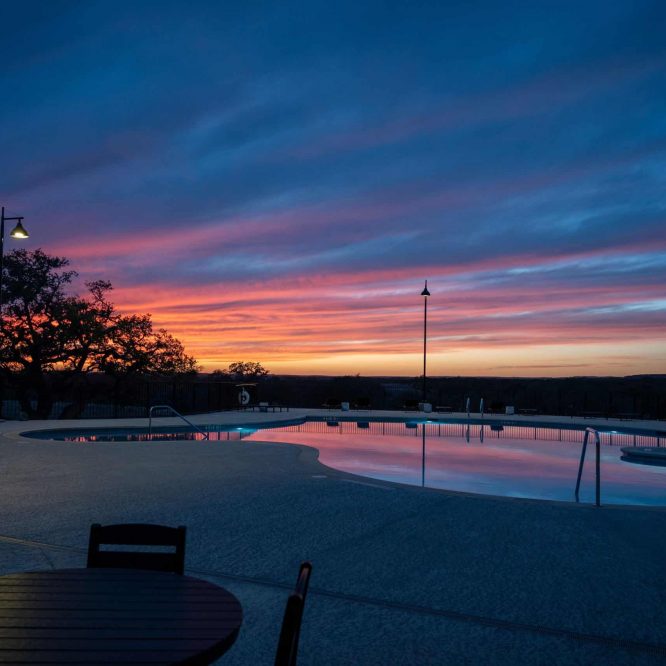 Scenic sunset over Horseshoe Ridge RV with pool and outdoor seating.