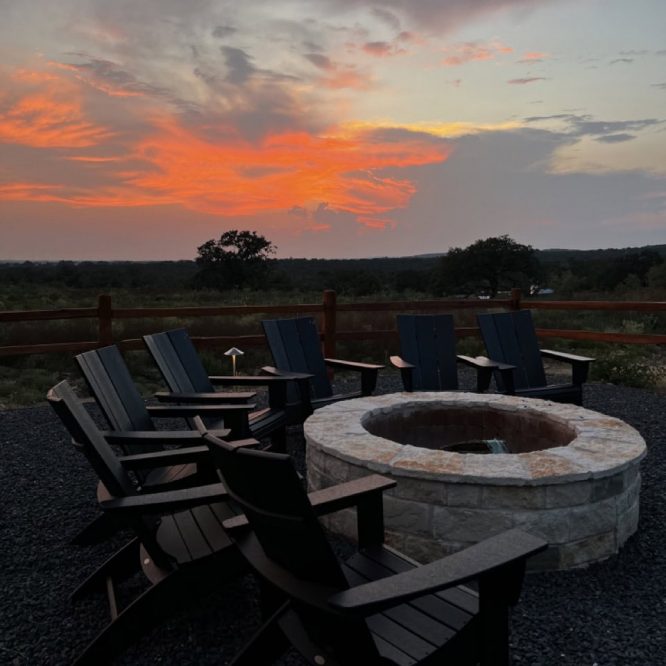 Sunset over Horseshoe Ridge RV with fire pit and chairs in foreground.